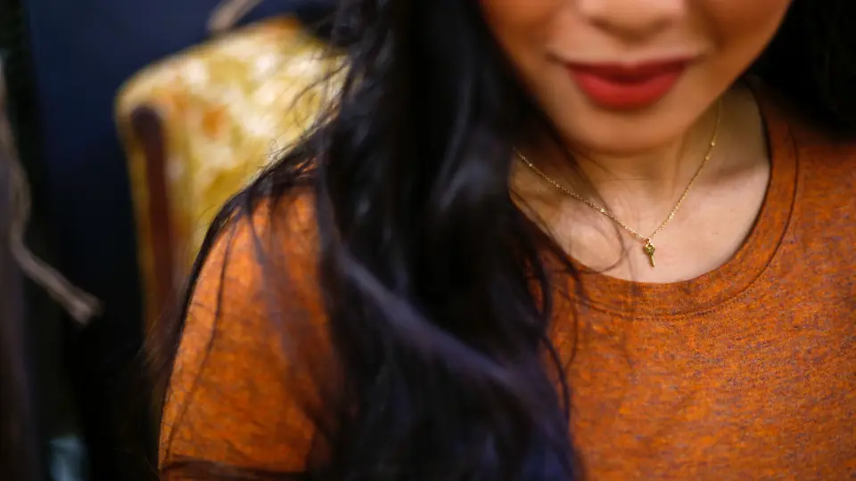 Erste Nachricht beim Sexdating: eine lächelnde Frau mit rotem Lippenstift und Halskette