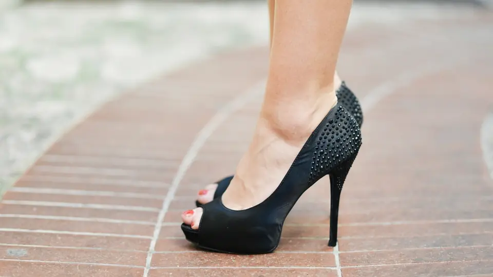 Sex Dating Traun: ein schwarzer High Heel auf Holzplanken